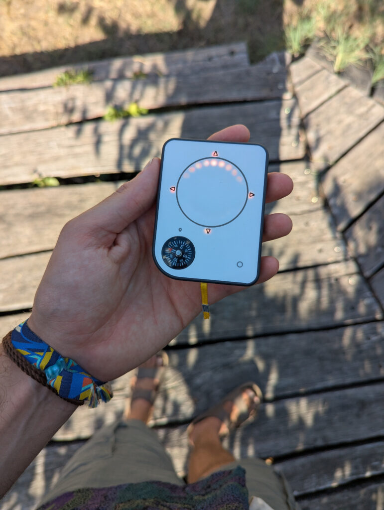 Person holding a Buddycompass festival tracker at a music festival.