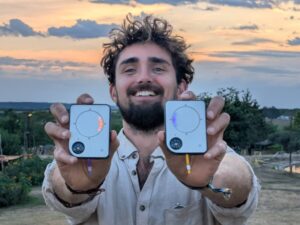 Person holding two Buddycompass festival trackers outdoors.